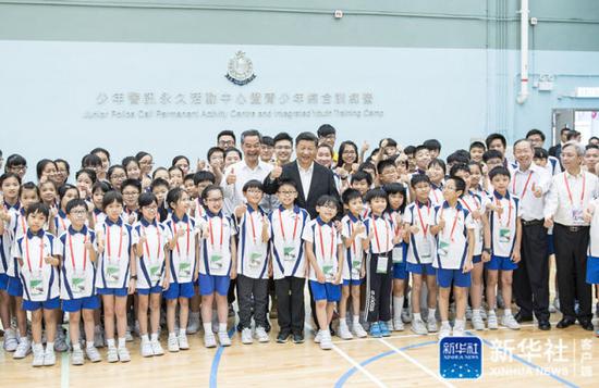↑6月30日上午,国家主席习近平来到香港少年警讯永久活动中心暨青少年综合训练营考察,看望正在训练的香港青少年。这是习近平同少年警讯成员合影。新华社记者 李涛 摄
