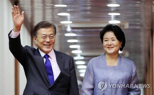 7月2日下午，在首尔机场，韩国总统文在寅（左）和第一夫人金正淑抵达首尔后挥手致意。（韩联社）