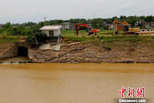 7月6日，宁乡灰汤镇乌江河冲垮的河提上，机械设备正在作业，为沿河群众修建出行便道。　曾蓓　摄