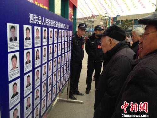 资料图:民众围观被曝光的“老赖” 刘林 摄