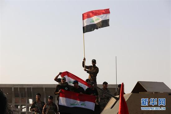 7月10日，在伊拉克摩苏尔举行的庆祝仪式上，一名伊拉克士兵挥舞国旗。伊拉克总理阿巴迪10日在位于摩苏尔前线的反恐部队指挥部宣布，极端组织“伊斯兰国”在摩苏尔的统治已被彻底推翻，这个城市于当天全面解放。伊拉克政府军2016年10月发起收复摩苏尔的攻势，今年1月收复东部城区，2月发起收复西部城区的军事行动。今年6月18日，伊拉克政府军从多个方向攻入“伊斯兰国”在摩苏尔的最后据点西部老城。新华社发（哈利勒·达伍德 摄）