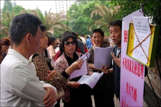 资料图：上海人民广场的“相亲角”，父母们忙着给孩子找对象。（BBC）