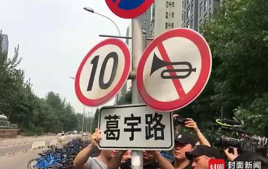 7月13日下午，在北京朝阳区双井附近的“葛宇路”，双井城管队的车辆驶入这里。之后，双井街道和城管人员对这一引发争议的路牌开始了拆除。