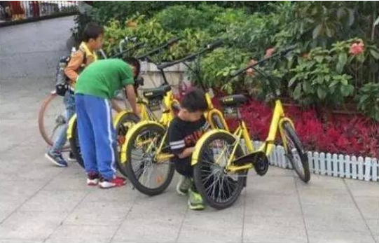 孩子们在尝试解锁共享单车