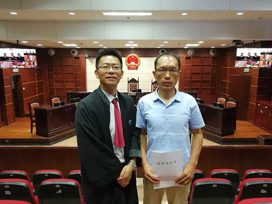 丁国勤（右）与其辩护律师胡泽明（左）。 律师供图
