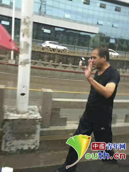 救起人离开后被市民拍下的高建军。中国青年网 图