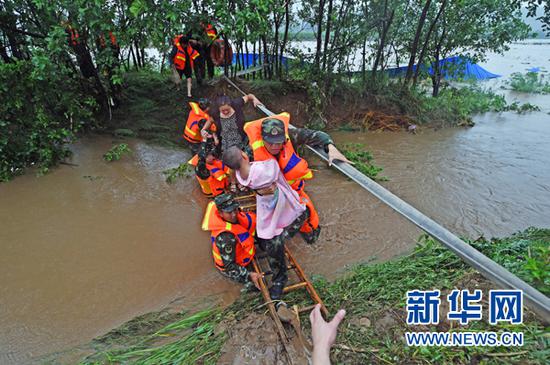 8月4日，在岫岩县巴家堡村，消防官兵救助被困村民。新华社记者 杨青 摄
