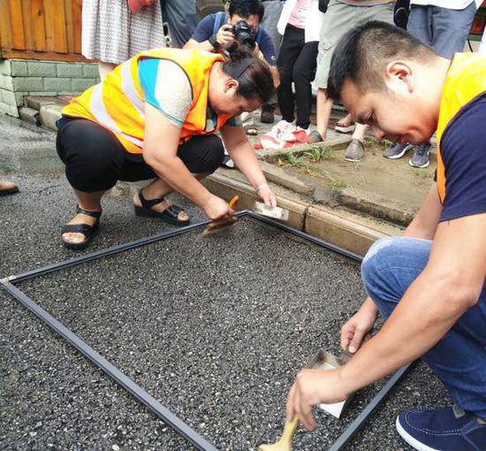 检查职员在检查清扫过的门路，以克论净。生涯报 图