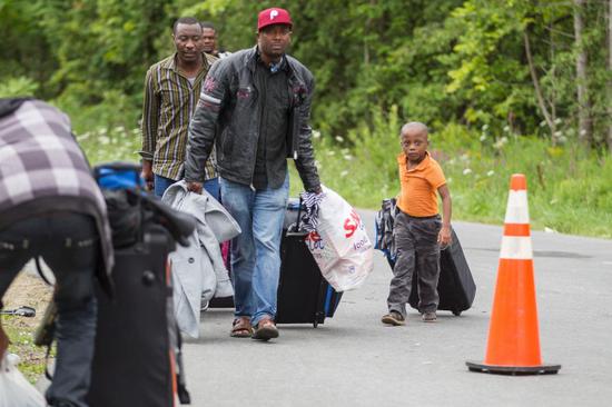 图为难民从从美加边界涌入加拿大