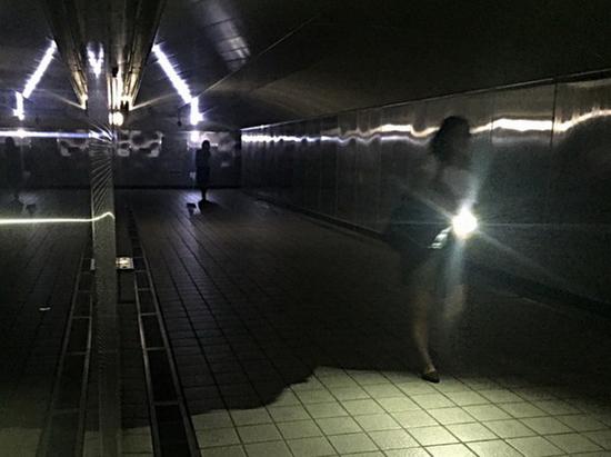 台北市松江路地下道受影响停电，民众自备手电筒点起灯光前进。