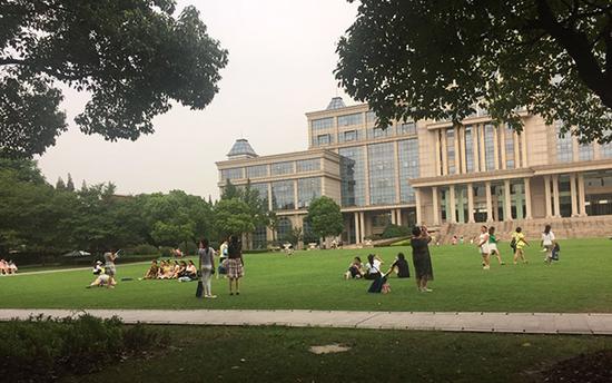 8月8日，复旦邯郸校区光华楼草坪，游客正在拍照。本文图片均为澎湃新闻记者 臧鸣 实习生 杜慧 图
