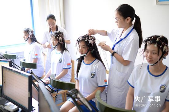 参加定选检测的女学生进行脑电图检测。