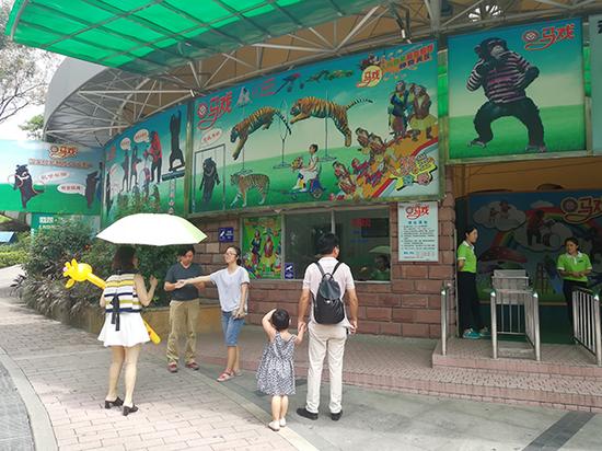 广州动物园工作人员在动物行为展示馆门前对有意愿观看马戏表演的游客进行劝阻。