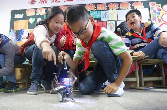 2016年5月16日,孩子们在公然课上学习机械人演出。