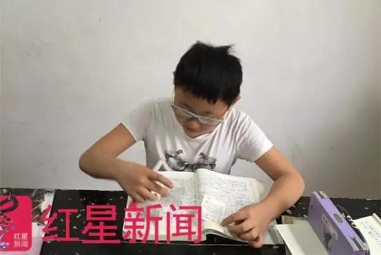 学生带着张平易近弢创造的防近视眼镜。