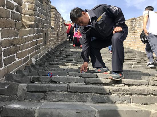 10月3日,当了33年长城环卫工的王茂海,随时弯腰捡地上的垃圾,他说,这已经是他的“职业病”。本文图片 澎湃新闻记者 赵实