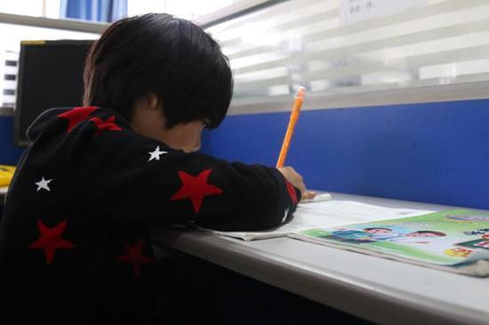 骆红玖值班时，女儿微微独自写作业。