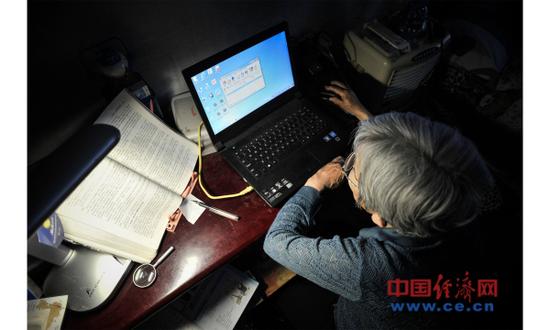 资料图片:2017年5月17日,天津。薛敏修在利用电脑学习。2014年,78岁的薛敏修正式成为天津大学现代远程教育电子商务专业的本科学生。(图片来源:视觉中国)