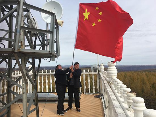 10月1日,刘军、齐淑艳夫妇登上望火楼顶,手持国旗向国庆献礼。本文图片均来自澎湃新闻记者 王哿