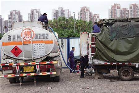 油罐车在给白色货车送油