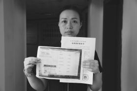 10日,柳女士展示法院的受理案件通知书,她因吃饭被收8元餐位费而状告餐厅。图/记者陈正