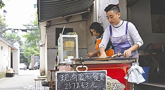 写着“爱心餐费”的小黑板挂在摊位上。陶轲 图