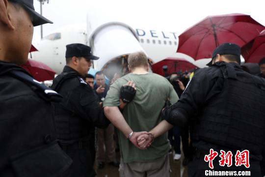 美籍红通逃犯被押送上航班。 张亨伟 摄