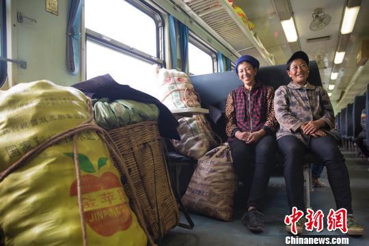 资料图:“扶贫”列车上,妇女正守护着自己的货物。 龚萱 摄