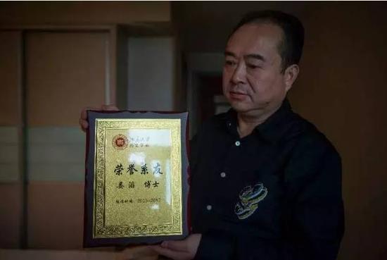 ▲北大历史学院领导将“荣誉博士”证书交给娄滔父亲