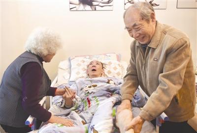 董海清老两口在给瘫痪在床之儿子董月做肢体推拿 摄影记者 张士博