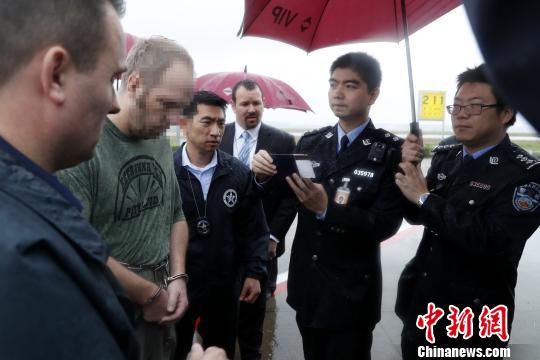 中国警方对美籍红通逃犯进行护照比对。 张亨伟 摄