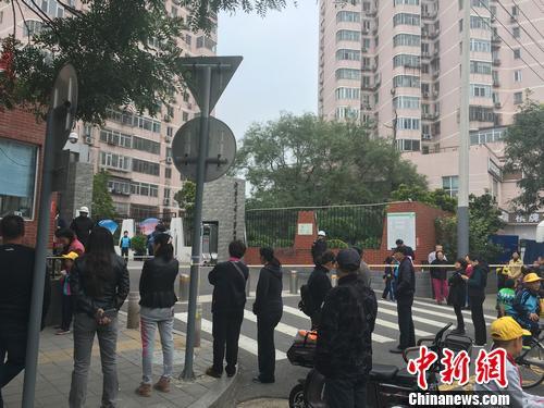 北京西城区一所小学外，不少家长正在等待孩子放学。汤琪 摄