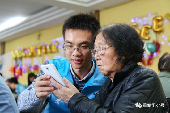 ▲志愿活动中,何绍森教老人使用手机。 受访者供图