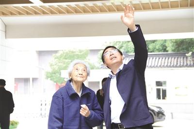 李伟平校长陪同周映芳老师(左)参观学校。
