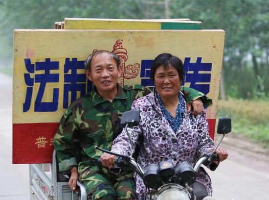 熊为义和闫怀玲开着三轮车去外地普法。邳州市司法局 供图