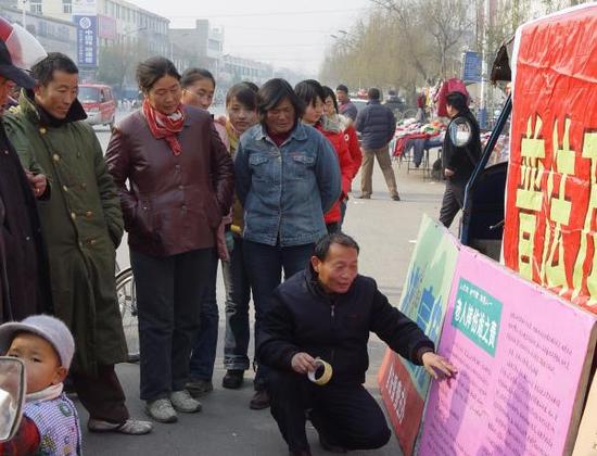 熊为义夫妇在街头宣传法律。邳州市司法局 供图