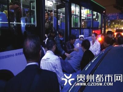 公交车开到医院门口，乘客和急救人员将患者背到担架上。
