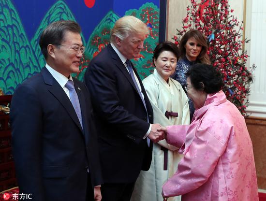 当地时间2017年11月7日，韩国首尔，美国总统特朗普偕妻子梅拉尼娅访问韩国，韩国总统文在寅为其举办国宾晚宴。特朗普在晚宴上拥抱问候一名慰安妇老奶奶。