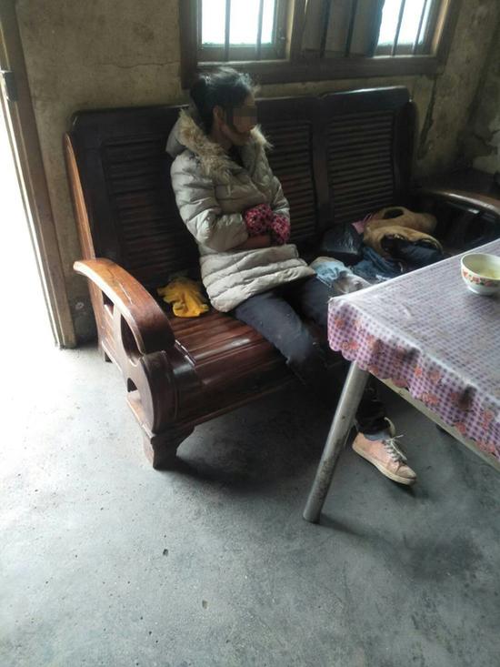 回来后的熊务美坐在娘家沙发上,双手抱臂,不措辞。 受访者供图