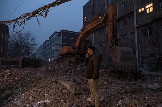杨泽在村中废墟上打电话。 澎湃新闻记者 周娜 图