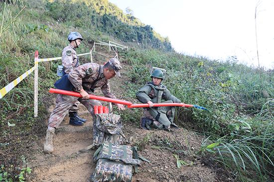 官兵们采用把扫雷爆破筒收尾相接、逐次爆破推进的方式进入雷场。