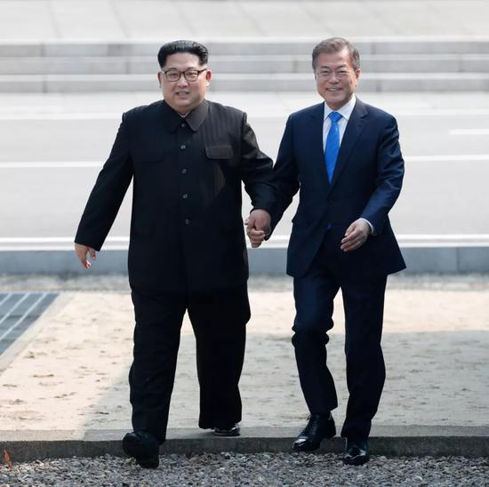 4月27日，朝鲜最高领导人金正恩（左）在板门店跨过军事分界线，与韩国总统文在寅会晤。新华社发（韩朝首脑会晤媒体报道团供图）