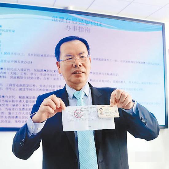 厦门市台商协会会长吴家莹,领取厦门首张居住证申请的号码牌。图源:厦门台商协会