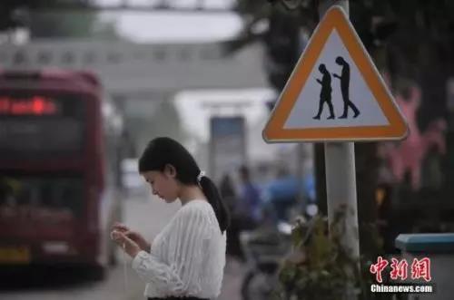 资料图：重庆一红绿灯处摆放“不做低头族、关注红绿灯”警示牌。 陈超 摄