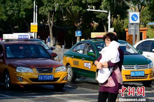 资料图:等红灯的出租车。中新社记者 刘文华 摄