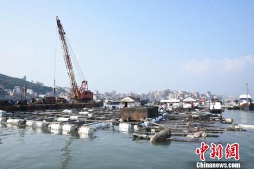 11月8日,在受碳九泄漏影響的泉州市泉港區肖厝碼頭,受損漁排加固工作仍在持續推進。圖爲起吊船對受損漁排進行加固。 陳龍山 攝