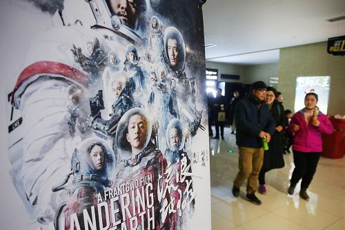 2019年2月10日，江苏省南通市，刚刚在一家影院看完《流浪地球》的观众在电影海报旁走过。（图片来源：视觉中国）