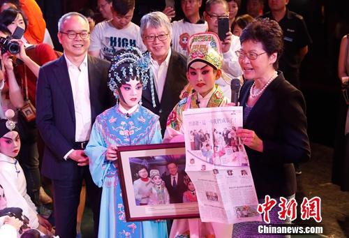 图为林郑月娥看望演员,并拿出刊载两位小演员成长历程的报纸文章。杜洋 摄