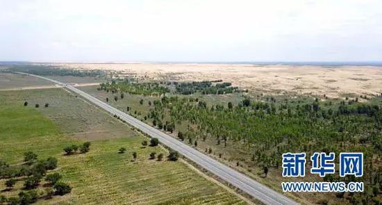 ▲汽车行驶在榆(林)靖(边)高速公路上(8月1日无人机拍摄)。穿越毛乌素沙漠的榆靖高速,是中国建成的第一条沙漠高速公路。