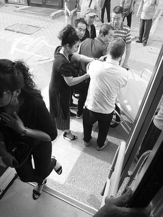 司机和乘客将老人送往医院。